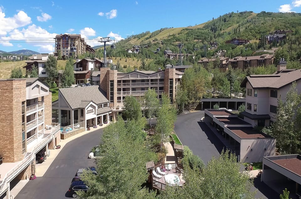 Nestled in a picturesque mountain valley, this alpine village setting offers a scenic backdrop of forested slopes and ski areas, with nearby parking and convenient access to local amenities.
