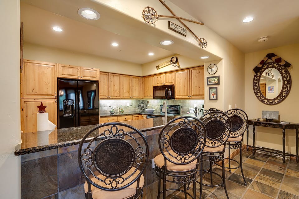 Gather around your fully equipped kitchen island with elegant bar seating—perfect for sharing meals and making memories with your travel companions in this inviting space.
