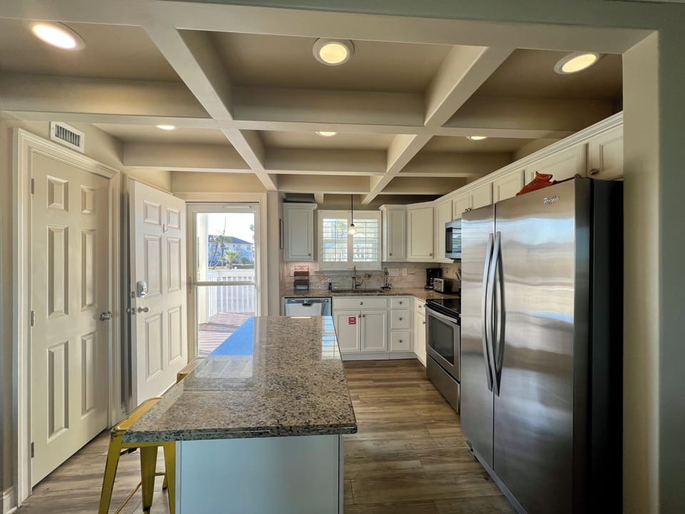 Your fully equipped gourmet kitchen awaits with granite counters, stainless appliances, and coffered ceilings for memorable meal prep.