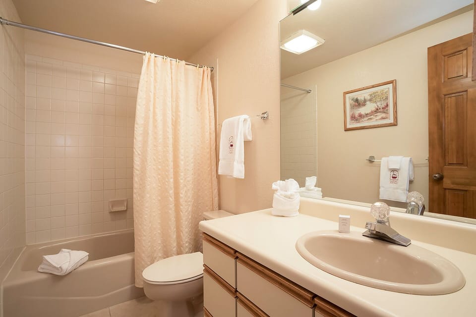Step into your private bathroom with fresh towels, a spacious tub-shower combo, and thoughtful touches ready for your comfort and relaxation.