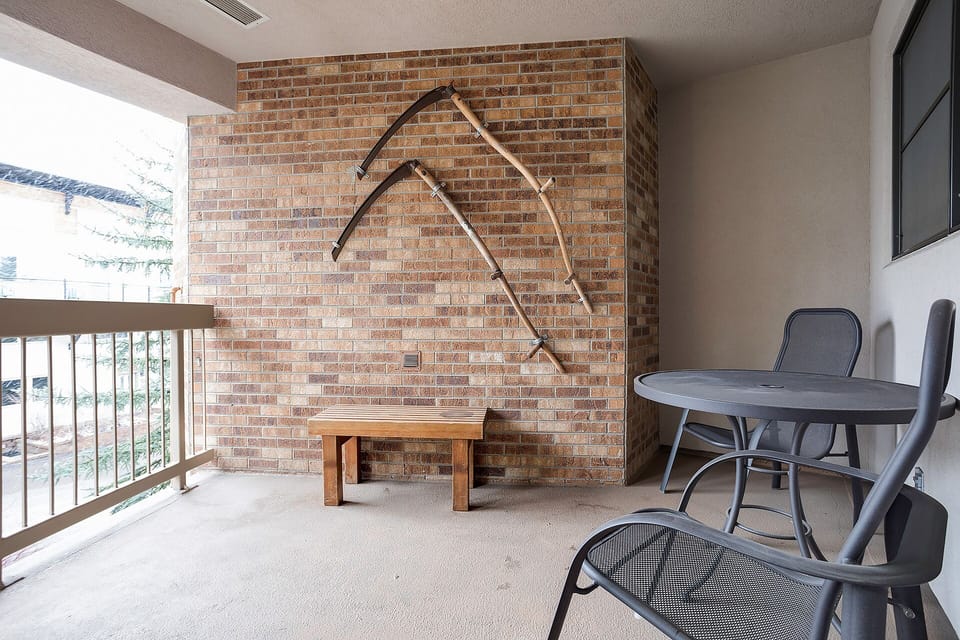 Unwind on your private balcony with mountain artwork, outdoor dining table, and peaceful views of the surrounding area.