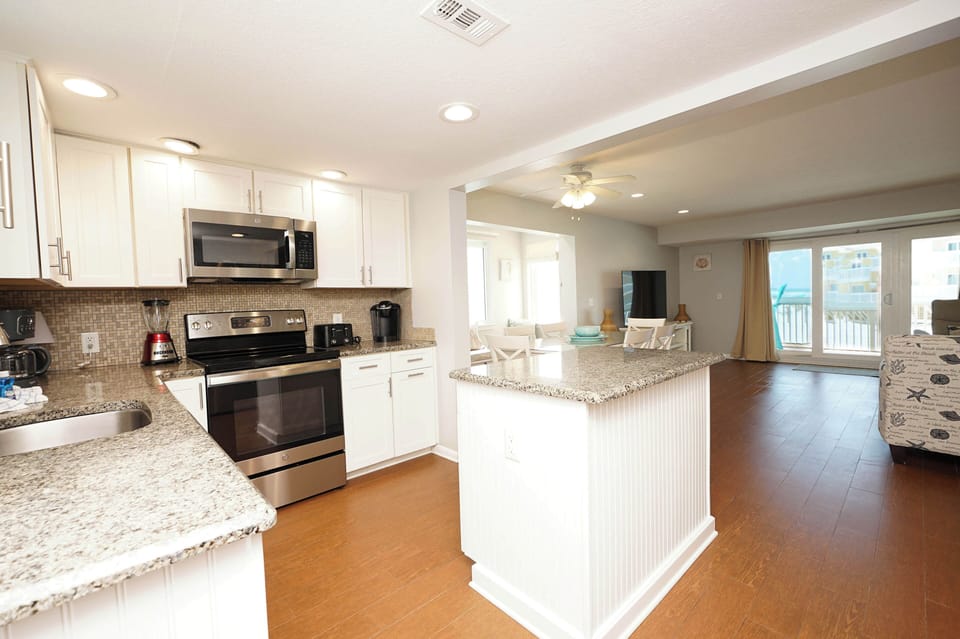 Your spacious open-concept kitchen flows seamlessly into the living area, featuring granite countertops and modern appliances for memorable vacation meals.