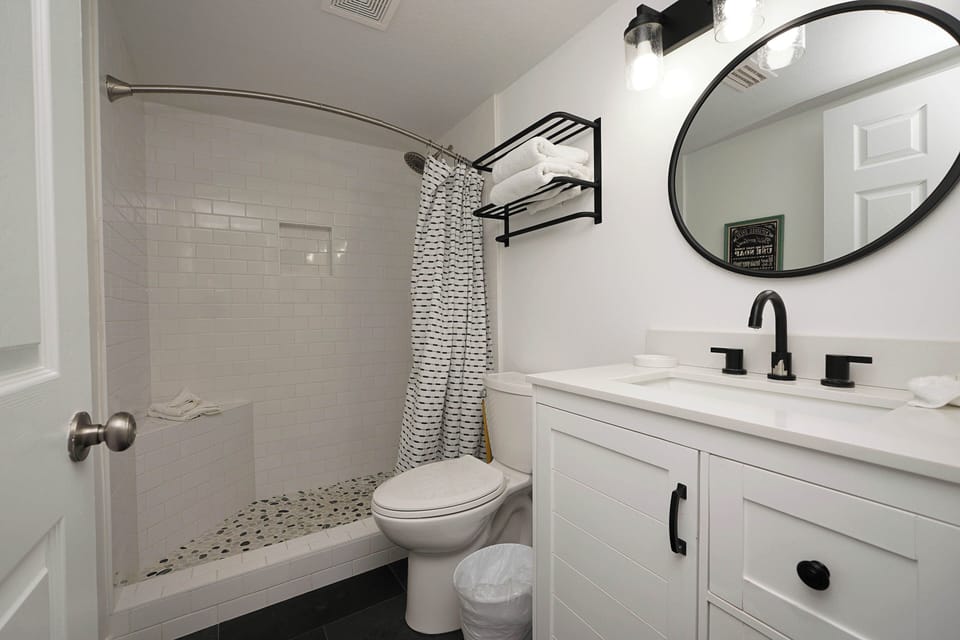 Step into your modern bathroom featuring a sleek walk-in shower with subway tile, stylish black fixtures, and fresh white towels ready for your arrival.