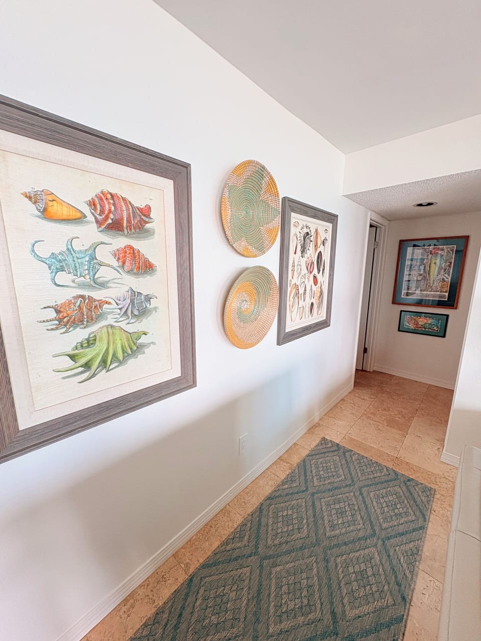 Your stairway features beautiful coastal artwork and handwoven baskets that create a warm, artistic atmosphere as you move through the space.