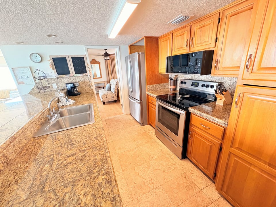 Your fully equipped kitchen features granite countertops, stainless steel appliances, and warm wood cabinetry—perfect for preparing meals during your stay.