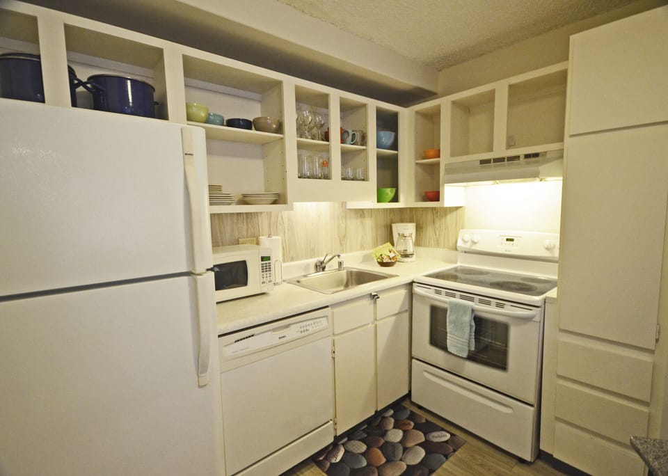 Kitchen includes refrigerator, microwave, coffee pot, stove/oven