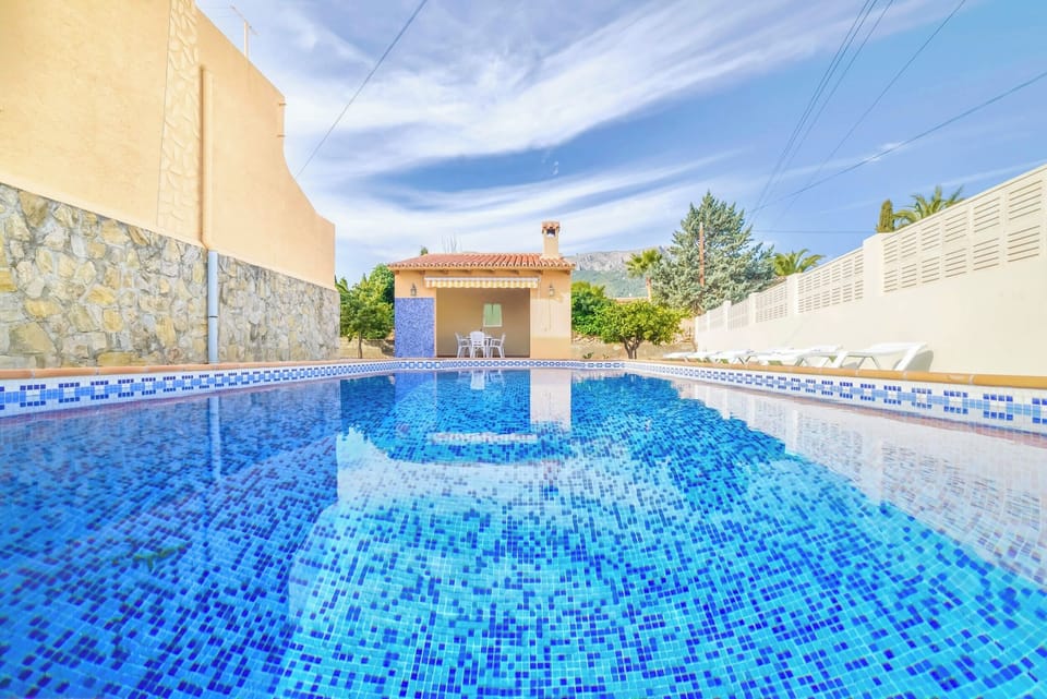 Holiday villa with private pool located in Calpe (Costa Blanca) for 8 people, with four bedrooms and three bathrooms distributed over two floors.INTERIOR: The GROUND FLOOR is closed and uninhabited during the rental. THE HIGH FLOOR: It is accessed by external stairs through the covered terrace with access to the large dining room and living room with SAT / tdt TV. It also has a separate kitchen with fully equipped gas fires. A room with a washing machine. There are two large bedrooms with 2 single beds each. A separate bathroom with shower. And two large bedrooms with a double bed each. Apart there is a toilet. The living room and all bedrooms are equipped with air conditioning.EXTERIOR: Nice 8x4 pool (1m min. and 1.70m max.) area with Roman stairs, covered construction barbecue and an outdoor shower. There is also a bathroom with shower. Parking on the plot for 2 vehicles.LOCATION: The villa is located in a privileged area called "Benicolada" near the center of Calpe 600 m as well as the sandy beach 1.3 km. The nearest supermarket is only 600 meters from the house.OBSERVATION: Free WiFi. Pets are allowed up to 12 kg with supplement.
