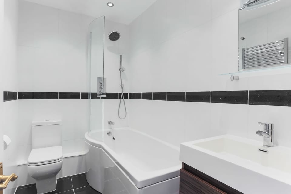 Spacious bathroom with a bath and overhead shower
