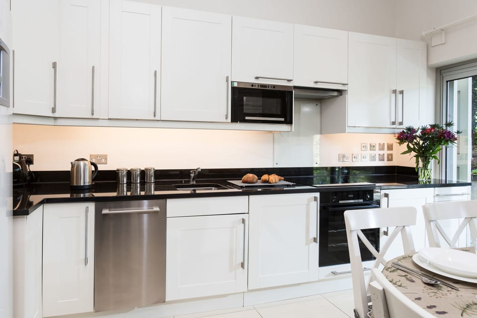 Well-equipped kitchen with an electric oven and hob and sliding door leading to the patio