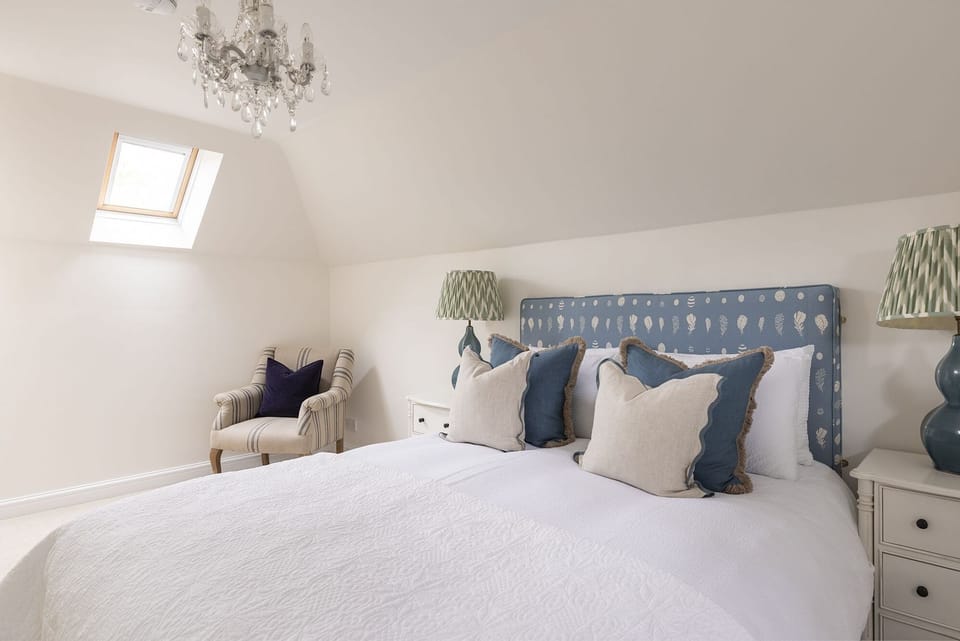 The Mill House - bedroom one with king size bed and armchair