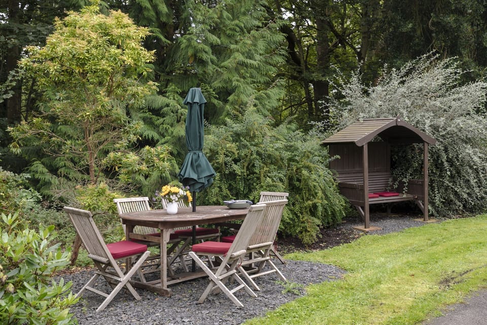 Monteviot Stables West - a dining table and chairs in the garden