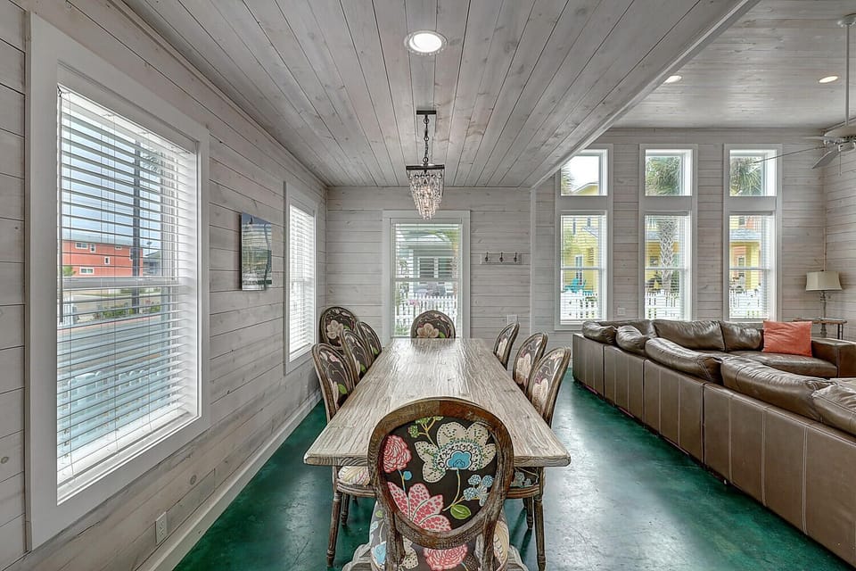 Gather around your elegant dining table beneath a sparkling chandelier, where memorable meals unfold in this bright, airy space.