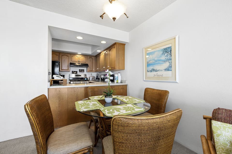 Gather around your dining table for meals or morning coffee, with a fully equipped kitchen just steps away. The coastal artwork and warm wood tones create a welcoming space for your vacation memories.