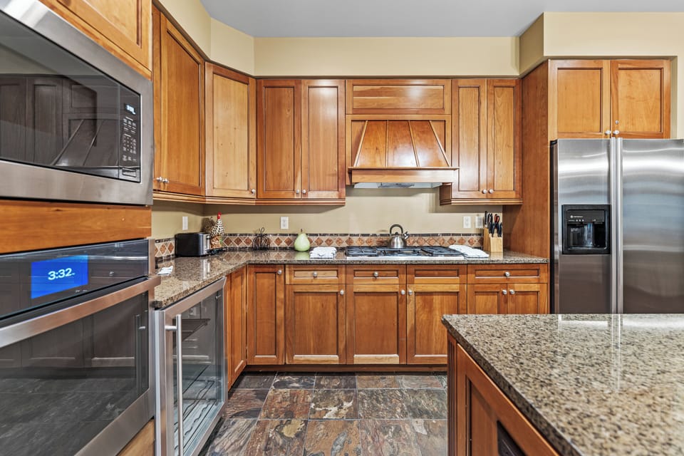 Step into your fully equipped kitchen with granite countertops, stainless steel appliances, and rich wood cabinetry for all your culinary adventures.