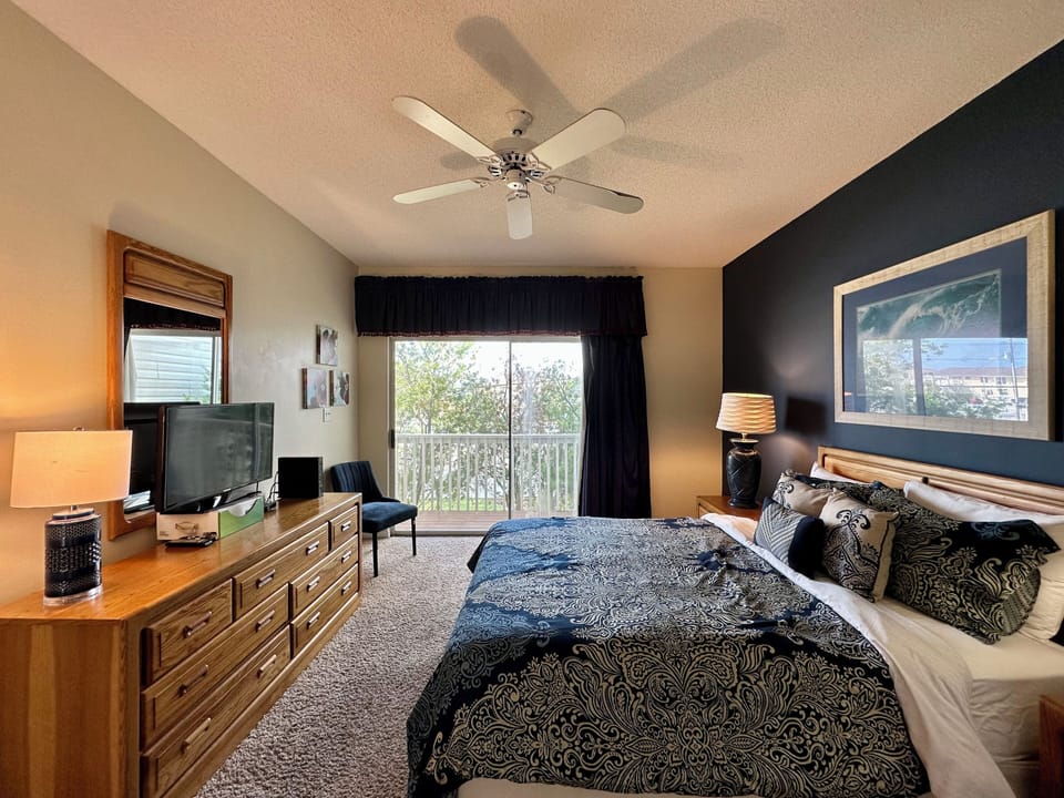 Relax in your elegantly appointed bedroom featuring a comfortable queen bed, modern furnishings, and peaceful balcony views for restful nights.