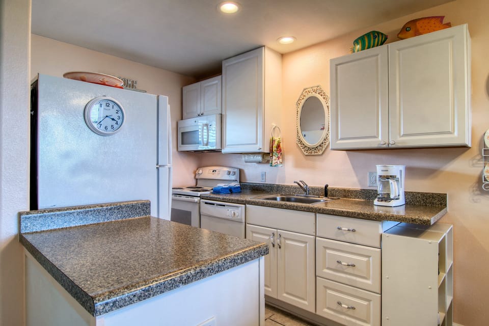 Your fully equipped kitchen features granite counters, white cabinets, and all appliances needed to prepare meals during your stay.