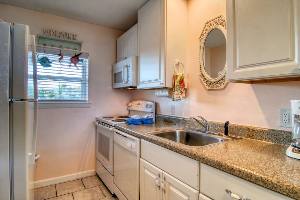 Your fully equipped kitchen welcomes you with granite countertops, white appliances, and cheerful décor that makes meal prep feel like home.