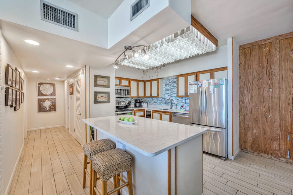 You'll love cooking in this bright, modern kitchen with its spacious island, sparkling countertops, and coastal-inspired design touches.