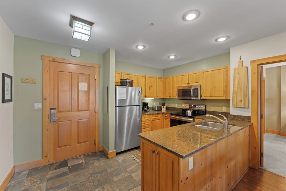 Your fully equipped kitchen features warm wood cabinetry, granite counters, and stainless steel appliances for memorable meal preparation.
