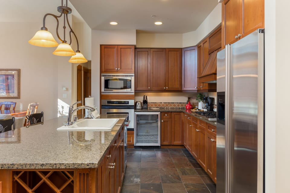 Your fully equipped kitchen features granite counters, stainless appliances, and warm wood cabinets—perfect for creating memorable meals during your stay.