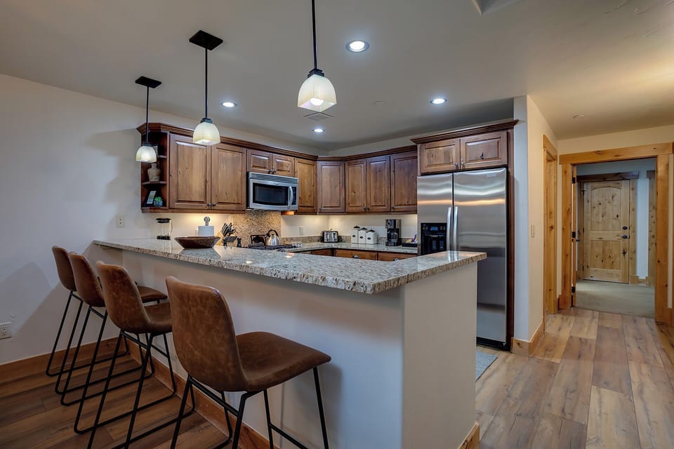 Your fully equipped kitchen features granite counters and breakfast bar seating, perfect for cooking meals together.
