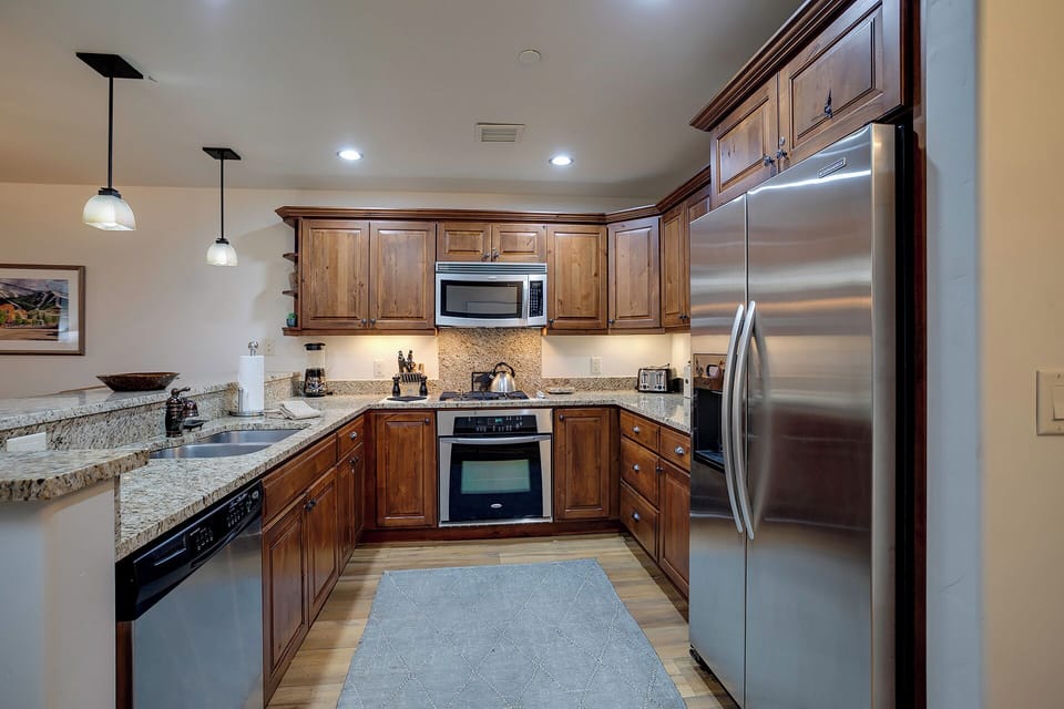 Your fully equipped kitchen features warm wood cabinetry, granite counters, and stainless steel appliances for memorable meal preparations.