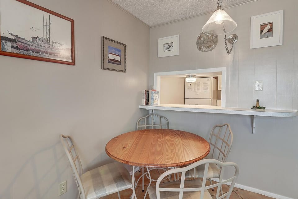 Gather around your cozy dining nook for morning coffee or evening meals, surrounded by charming nautical artwork and warm ambient lighting.