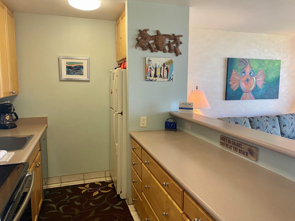 Your beach-themed retreat features a fully equipped kitchen with ample counter space, charming coastal artwork, and all the comforts of home for preparing meals together.