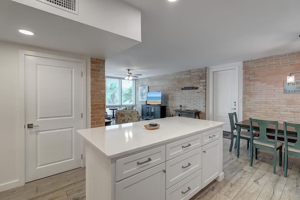 Your spacious kitchen island flows into a warm living area with exposed brick walls and modern amenities for memorable meals together.