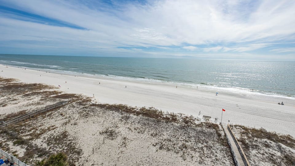 Gentle waves meet the soft sand and guests stroll along the beach