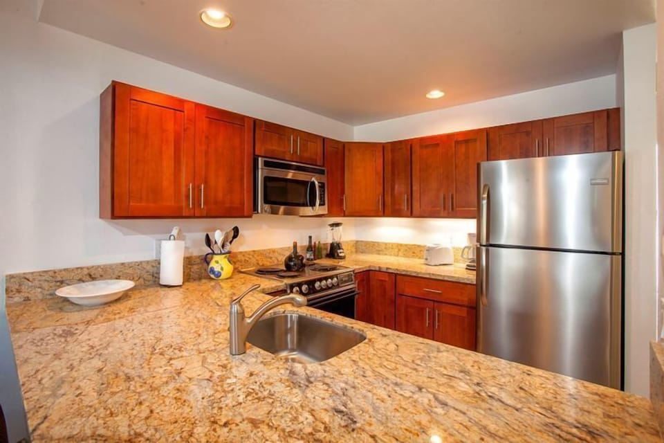 Step into your fully equipped kitchen with granite counters, stainless steel appliances, and rich cherry cabinetry—perfect for preparing meals during your stay.