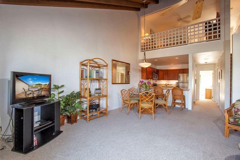 Step into your spacious open-plan retreat where vaulted ceilings with exposed beams create an airy, tropical feel. Relax in the living area or gather around the dining table, with your fully-equipped kitchen just steps away.