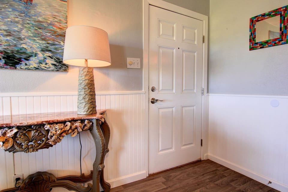 Your cozy entry welcomes you with coastal charm—beautiful artwork, warm lighting, and elegant details create the perfect arrival experience.