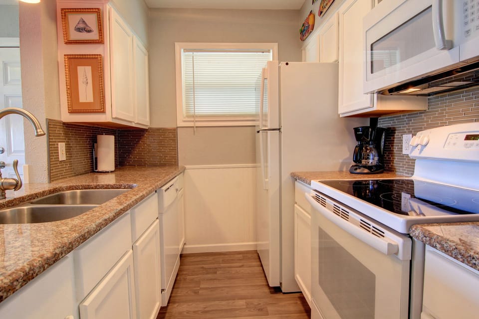 Your fully equipped galley kitchen features granite counters, white appliances, and everything you need to prepare memorable meals during your stay.