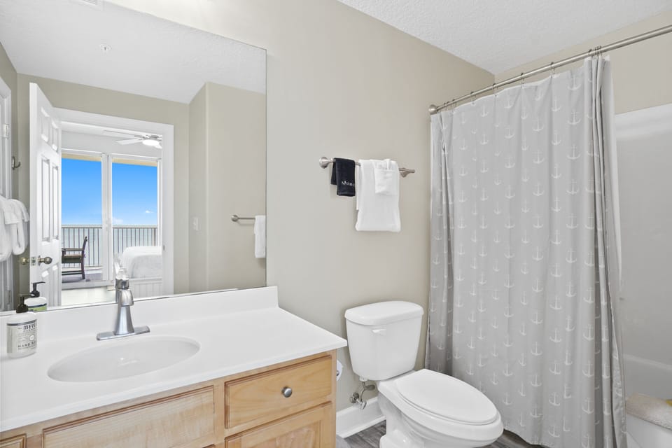 En suite Tub / shower combo with wall hair dryer.