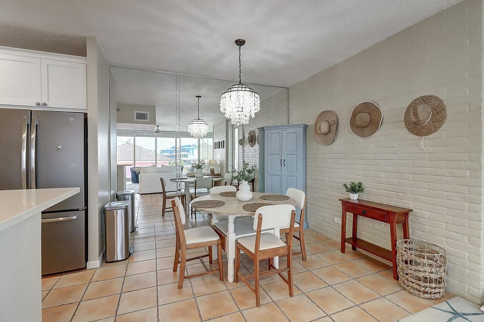 Gather around this inviting dining space where sparkling chandeliers illuminate your meals and coastal charm surrounds you with natural textures and ocean-inspired decor.