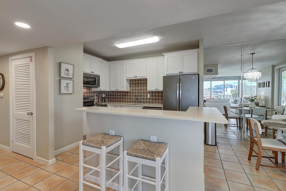 Your fully equipped kitchen features modern appliances, stylish tile backsplash, and convenient breakfast bar seating for casual dining.