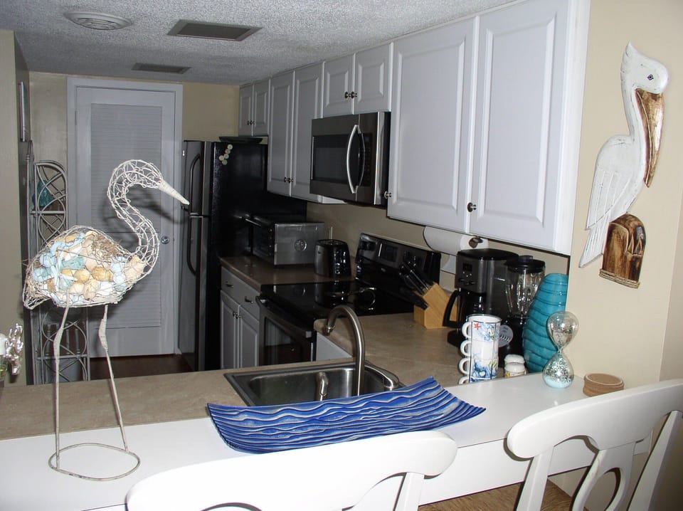 View of Kitchen from Living Room. (White chairs replaced 5/20)