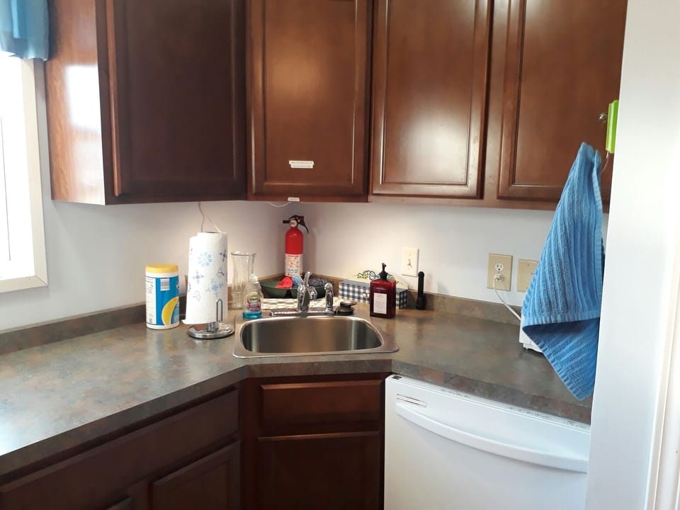 The full kitchen includes dishes and silverware along with a dishwasher.