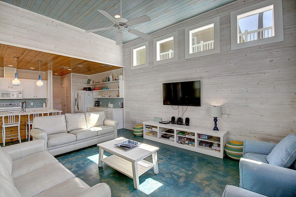 Relax in your open-concept haven with soaring ceilings, cozy seating, and a fully equipped kitchen - perfect for unwinding after your coastal adventures.