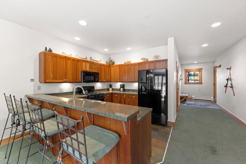 Your fully equipped kitchen features granite counters, modern appliances, and bar seating perfect for morning coffee or casual meals together.