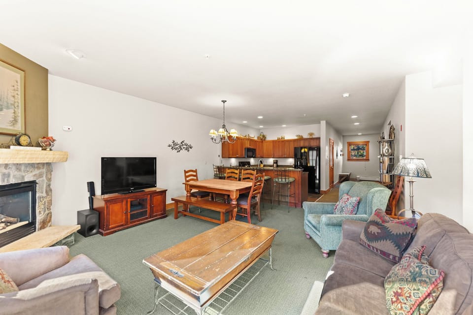Unwind in your spacious living area where cozy seating surrounds a warm fireplace, perfect for evening relaxation after mountain adventures.