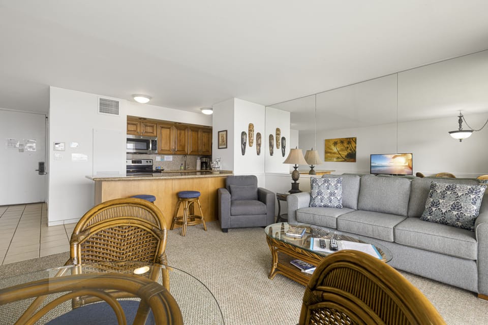 Settle into an open-concept retreat where the living room flows seamlessly into your fully equipped kitchen. Relax on plush seating, enjoy tropical-inspired décor, and savor the convenience of having everything you need within reach.