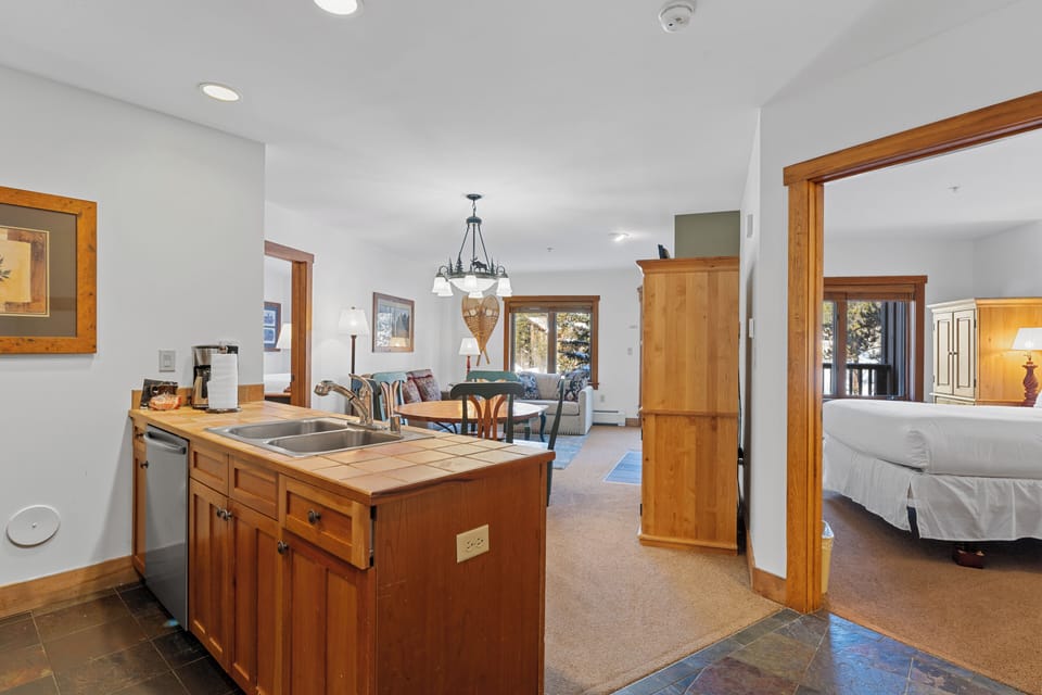 Your spacious suite flows seamlessly from kitchen to living area to bedroom, with warm wood accents creating a cozy mountain retreat atmosphere.