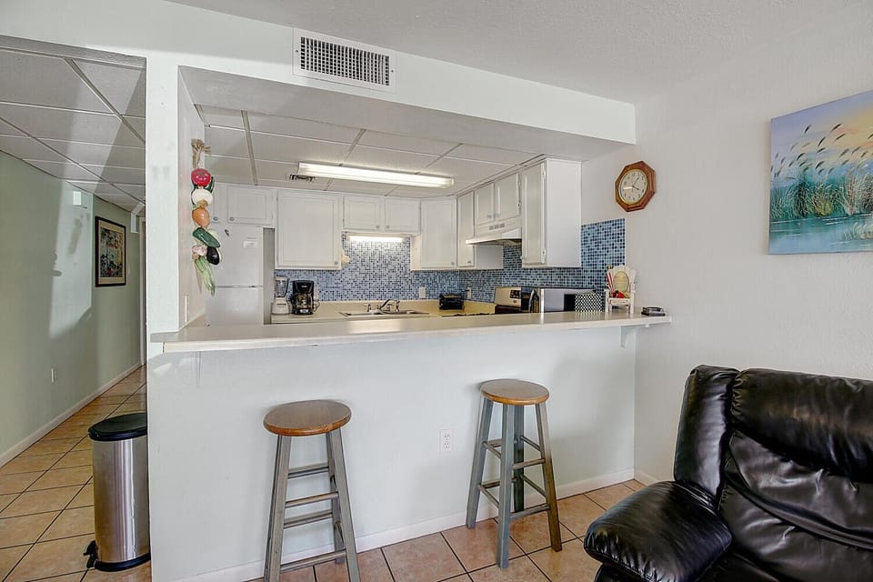 Gather around your spacious breakfast bar where mornings begin with coffee and conversation in this bright, fully-equipped kitchen.