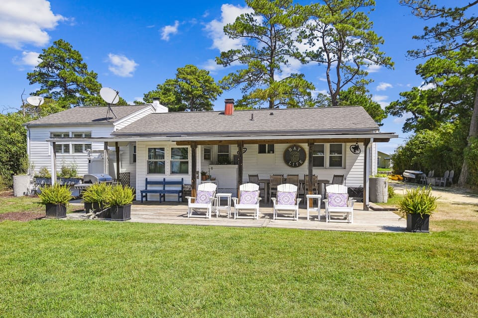 Backyard: reclining Adirondack chairs with ottomans, grassy area, table seating