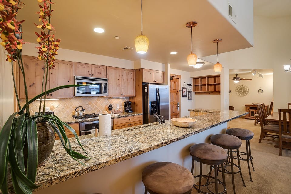 Your spacious kitchen features granite counters, stainless appliances, and a breakfast bar where you'll start each morning.