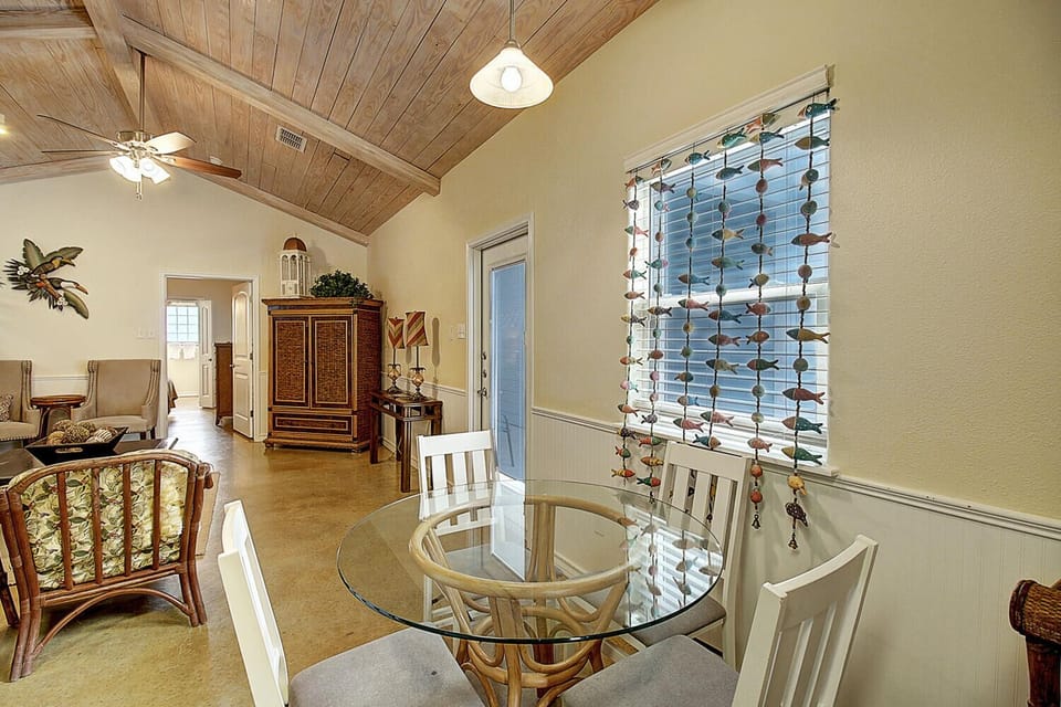 Relax in this bright dining space with vaulted wood ceilings and tropical charm, where your morning coffee feels like a vacation.
