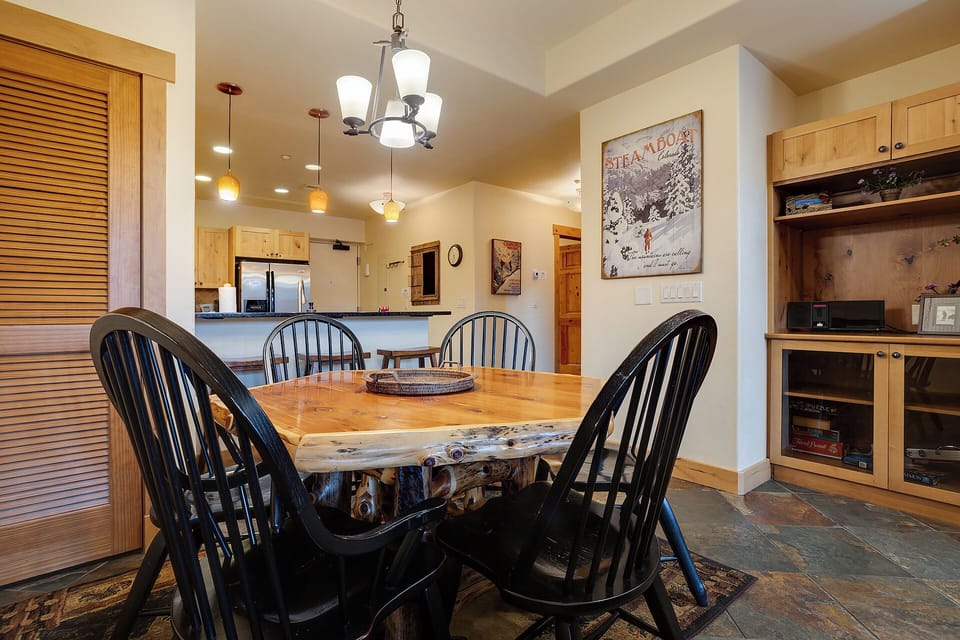 Gather around your rustic dining table, where warm wood meets modern comfort in this inviting open-concept space.
