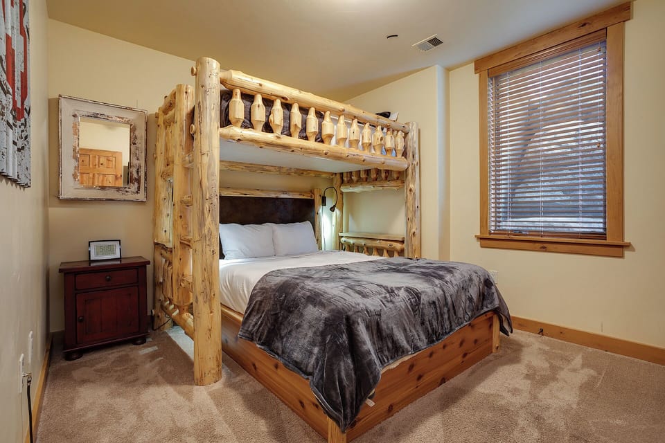 Rest in rustic comfort with handcrafted log bunk beds, crisp linens, and cozy mountain cabin charm in your peaceful bedroom retreat.